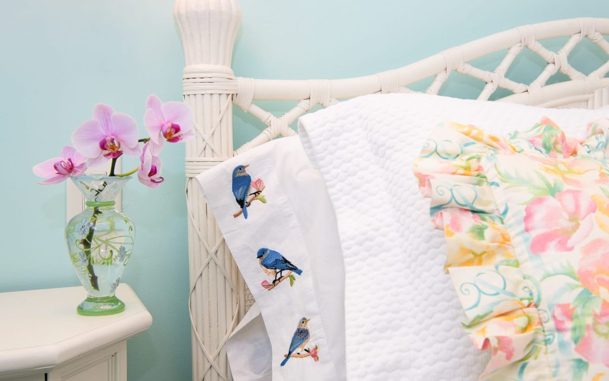 A pillow with birds and an orchid.