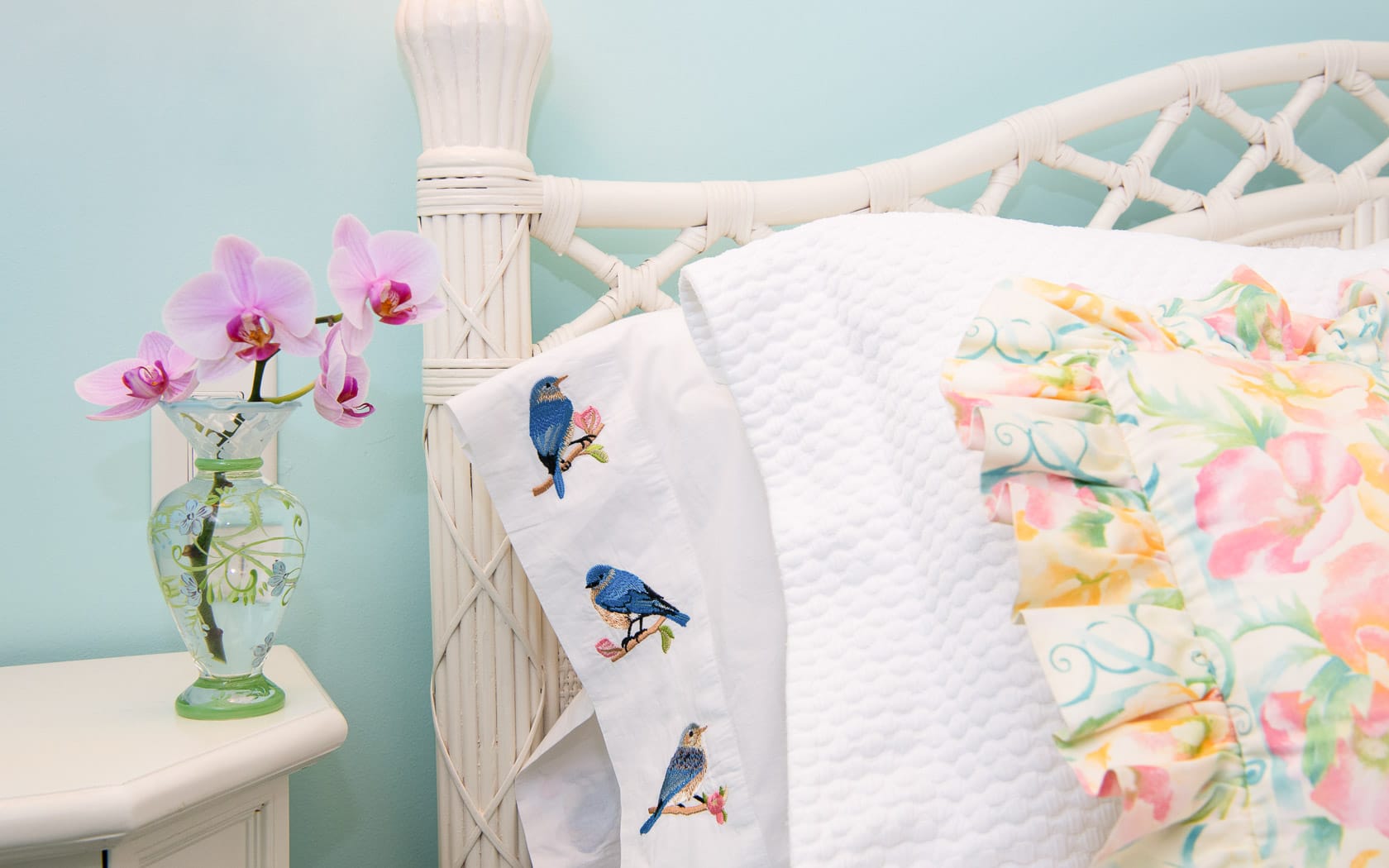 A pillow with birds and an orchid.