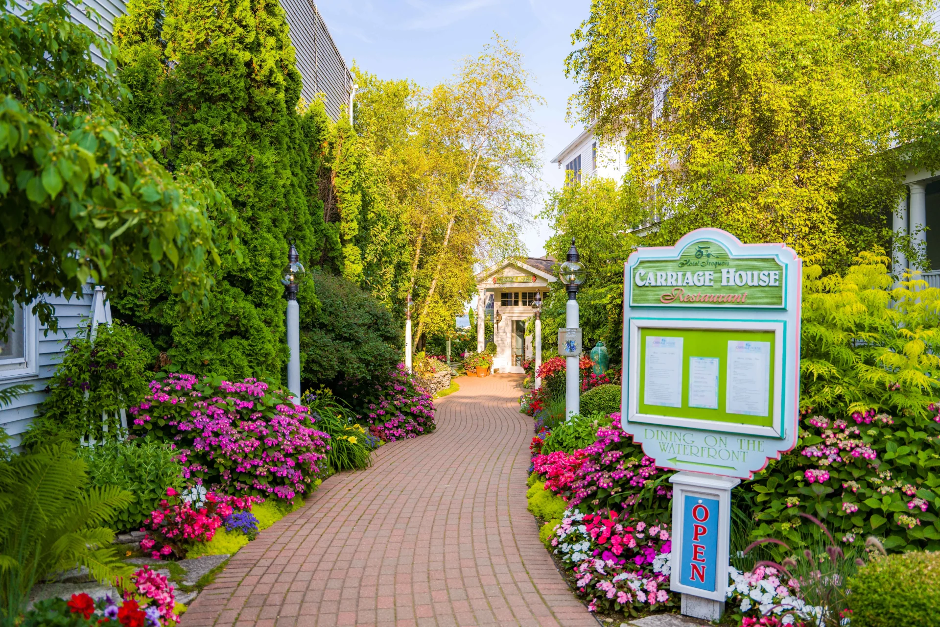 a brick path leading through a flower garden on both sides.