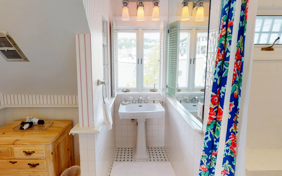 White bathroom with view of sync looking outside.