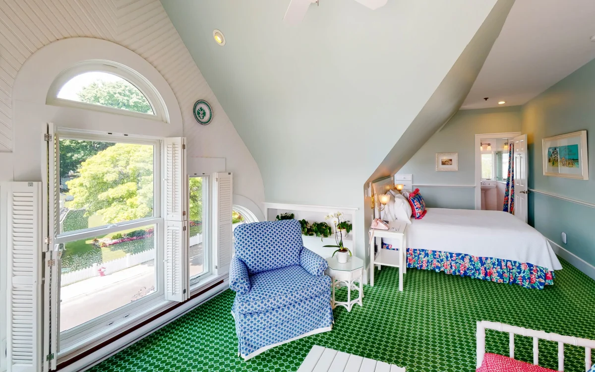 Blue chair and a green room of green carpet.