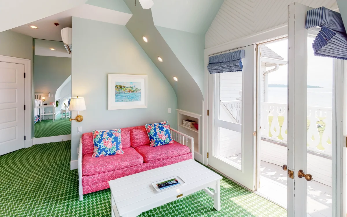 A pink couch looking out onto a balcony.