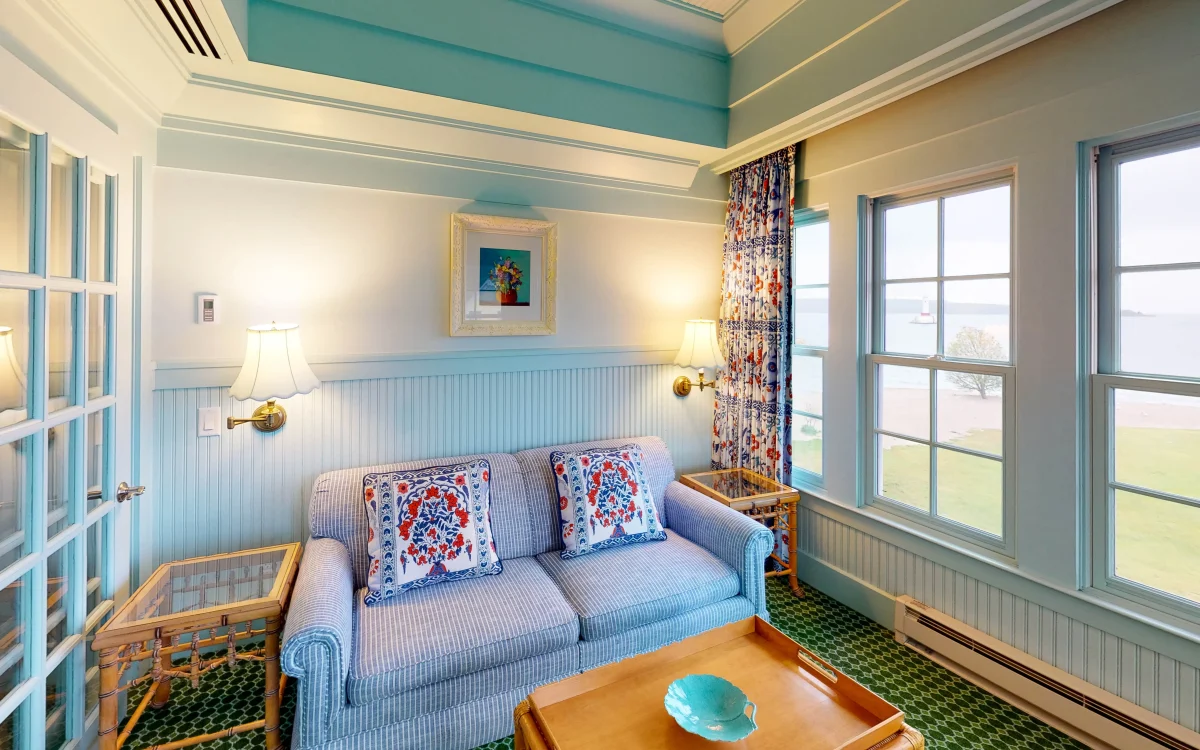 a blue couch in a green carpeted room.