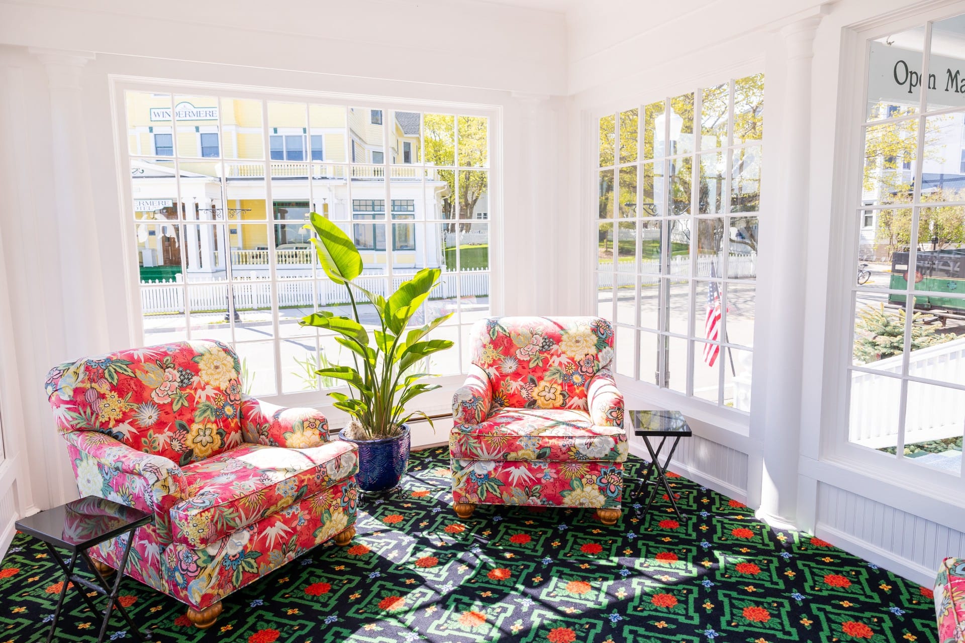 Pink chairs in a pattern carpet room with lots of natural light from windows.