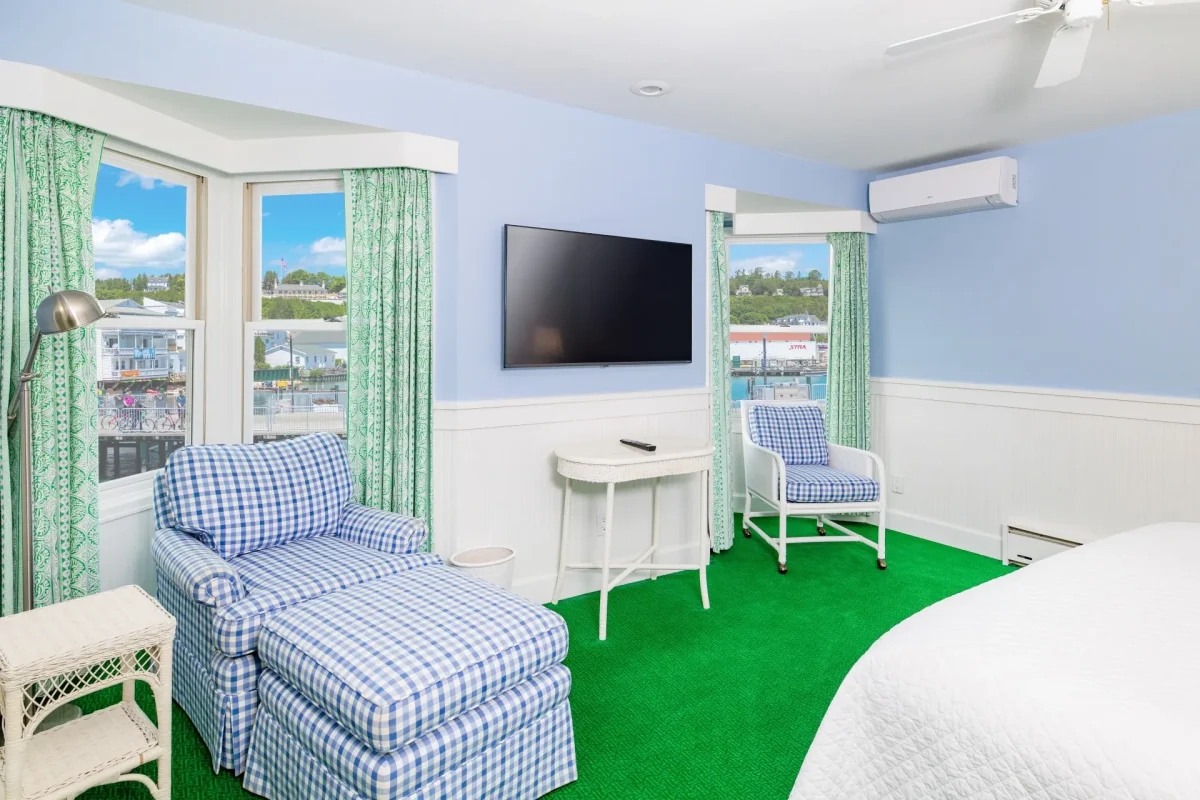 A blue chair and a blue room with television and windows.