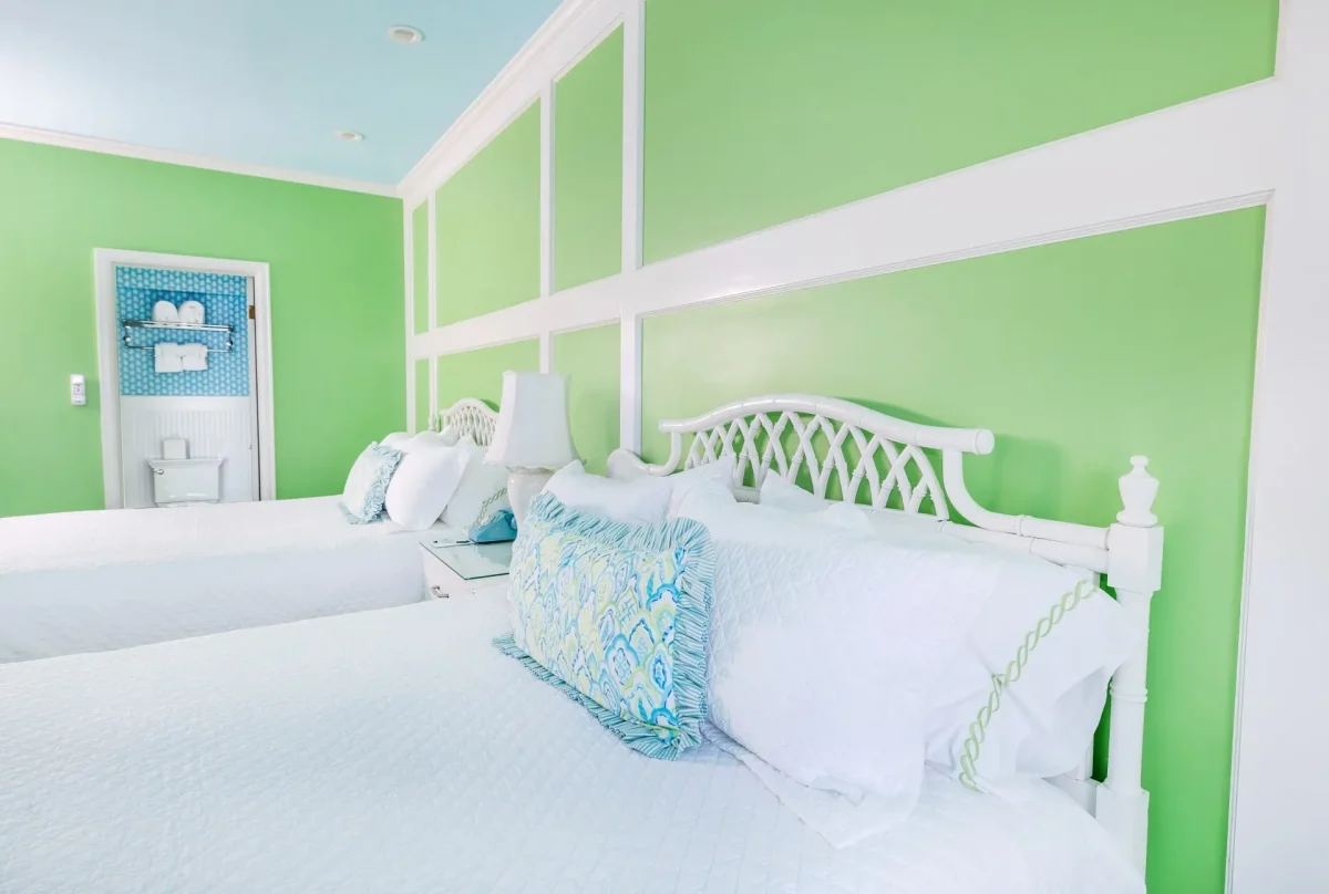 Two queen beds with view of a hotel bathroom.