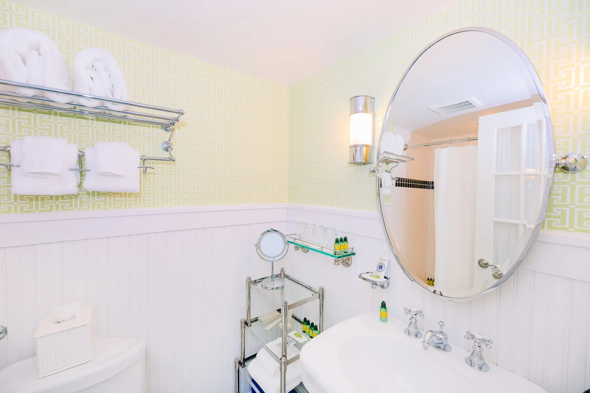 White bathroom with yi green accent walls with view of sink and mirror.