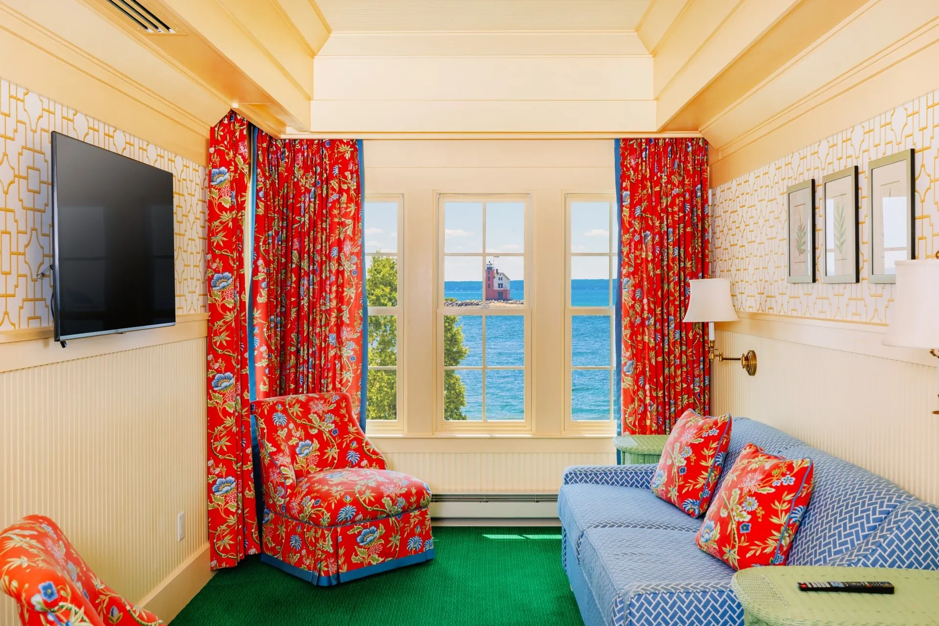 A cream colored room with green carpet with view of the door.