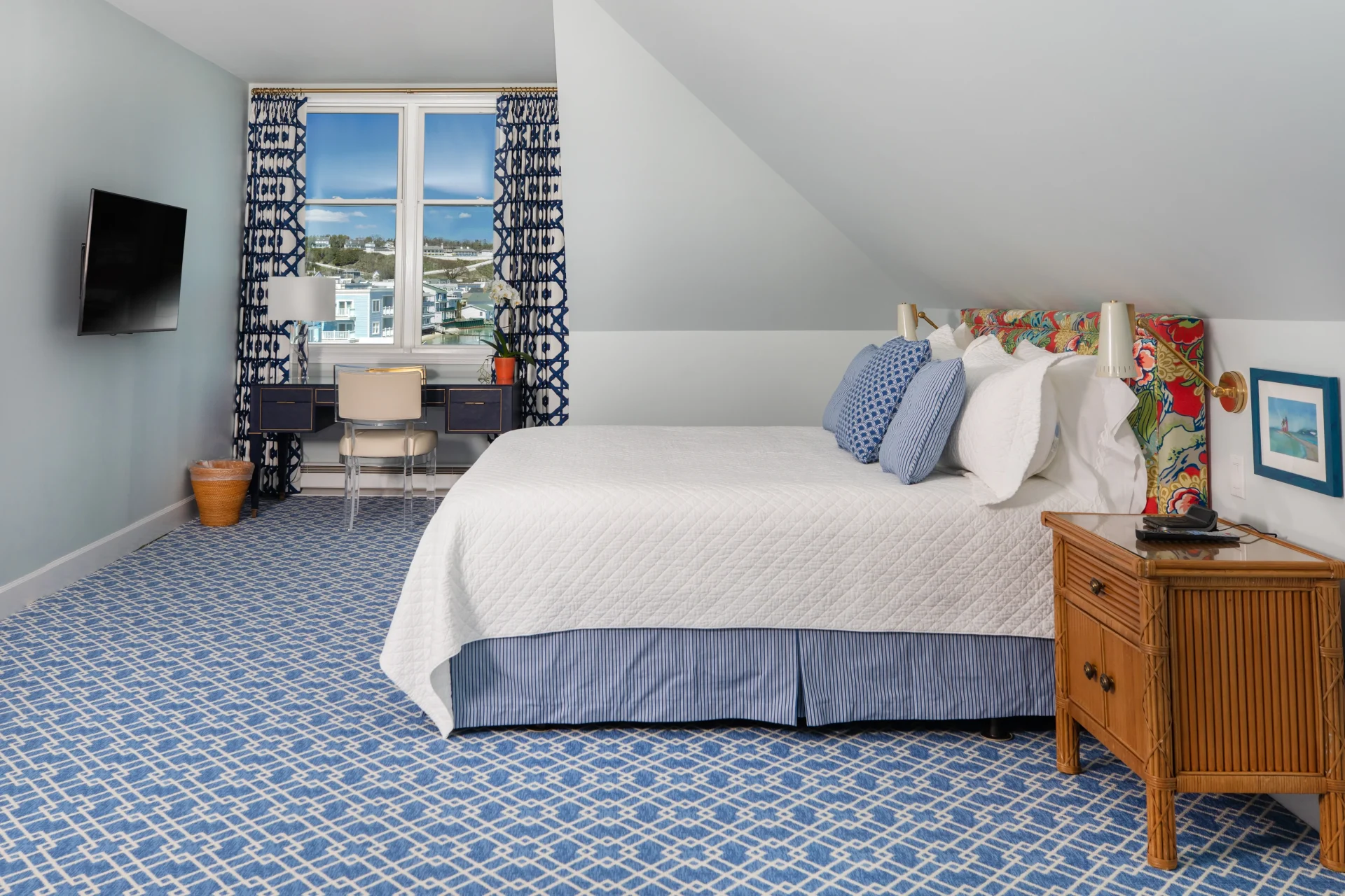 Blue pattern carpet room with gray paint, white bed and window of the lake.