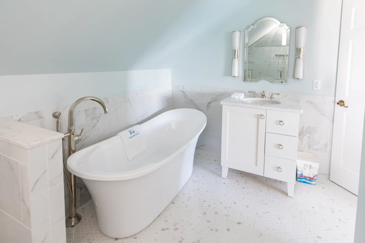 A white tiled bathroom with side fill bathtub.
