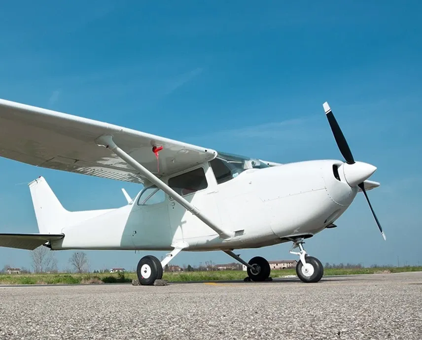 A white single propeller plane sitting on a strip.